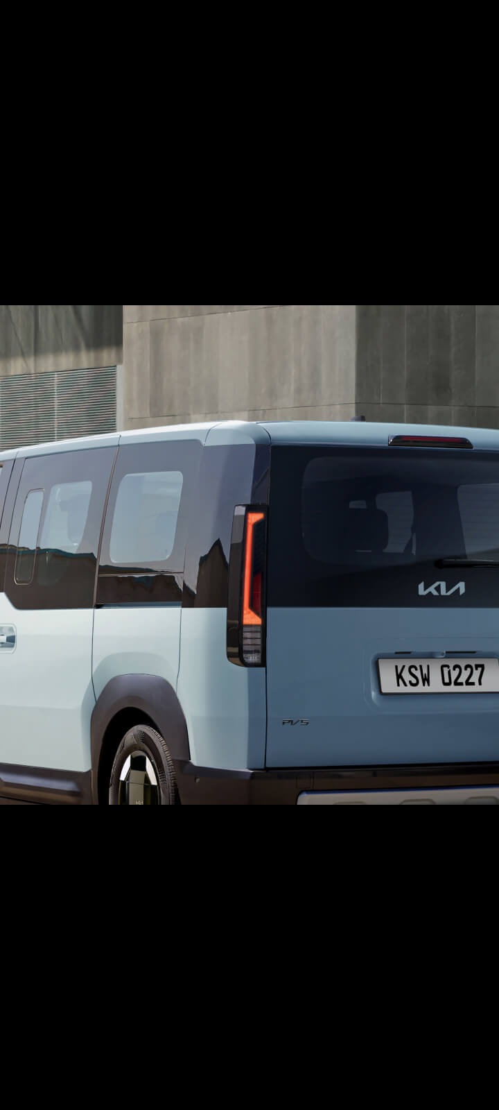 Schräger Blick aufs Heck des Kia PV5 Passenger mit vertikalen Rückleuchten